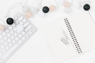 Beyaz klavye, Açık Not defteri ve beyaz, siyah, altın, gümüş Noel ışık garland beyaz arka plan dokulu. Bloglama kopya alanı için tatil şablonu