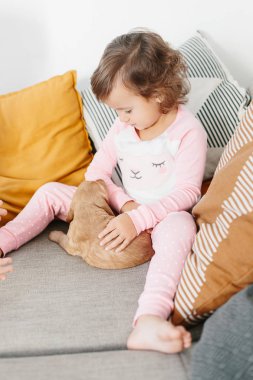 Evde köpek İngiliz yavru horoz İspanyol köpekle oynayan sevimli küçük kız. Çocuk ve pets birlikte