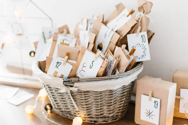 Varış takvimi Noel bekliyor. Numaraları ve kabine üzerinde duran çocuklar için görevleri ile zarflarla sepeti