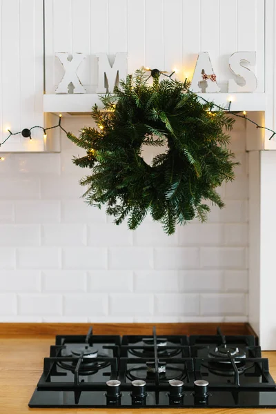 Noel çelenk xmas mektup dekor asma gaz soba beyaz Mutfak mobilya. Şık şık beyaz seramik tuğla duvar, ahşap masa üstü