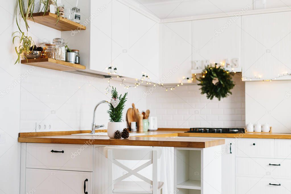 Small Christmas tree in white flower pot white modern kitchen scandinavian style decorated for Christmas background. Cypress, Chamaecyparis lawsoniana Ellwoodii