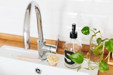 Arka plan beyaz lavabo sabun dispenseri ahşap tezgah ve beyaz seramik tuğla döşeme. Beyaz İskandinav mutfak detayları