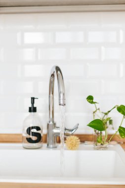 Arka plan beyaz lavabo sabun dispenseri ahşap tezgah ve beyaz seramik tuğla döşeme. Gezegen kavramı kaydetmek