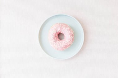 Mavi plaka üzerinde pembe donats backgrpund pastel renkler pembe. Tatlı kahvaltı