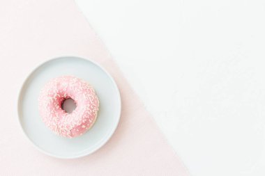 Mavi plaka üzerinde pembe donats beyaz arka plan pastel renkler pembe. Tatlı kahvaltı