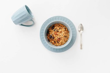 Granola beyaz dokulu arka plan üzerinde mavi kapta. Sağlıklı kahvaltı Günaydın