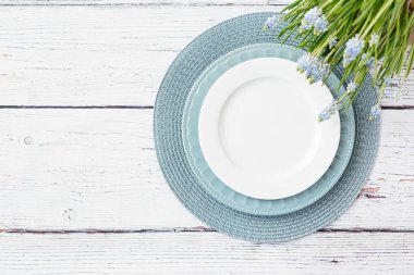 Bahar tablo ayarları üstten görünüm. Mavi ve beyaz tabak bahar muscari çiçekleri ahşap arka plan üzerinde metin için yer