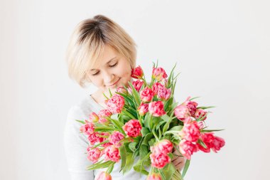 Mutlu çekici orta yaşlı sarışın kadınla bir buket Kırmızı Pembe Beyaz Lale