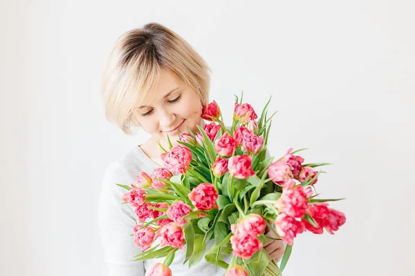 Mutlu çekici orta yaşlı sarışın kadınla bir buket Kırmızı Pembe Beyaz Lale