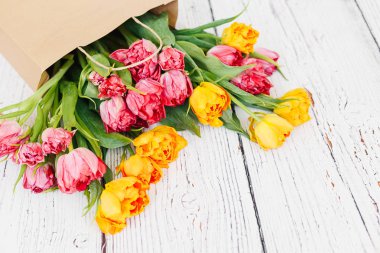 Beyaz ahşap zemin üzerinde kırmızı lale buketi