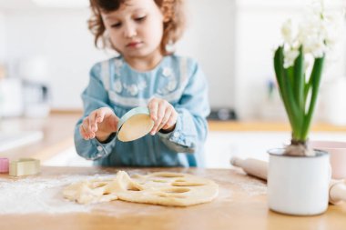 Küçük kız mutfak at Paskalya kurabiyeleri hazırlama.