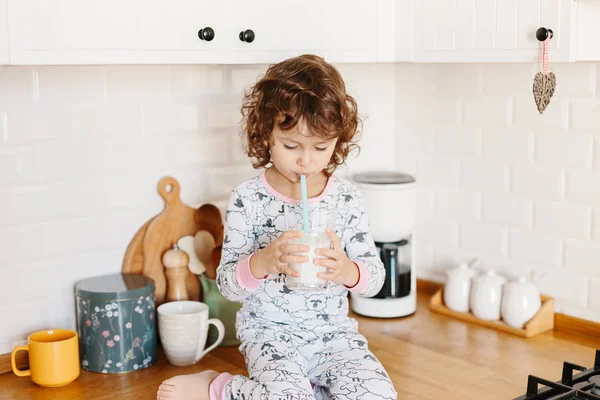 Menina vestindo pijama beber leite — Fotografia de Stock