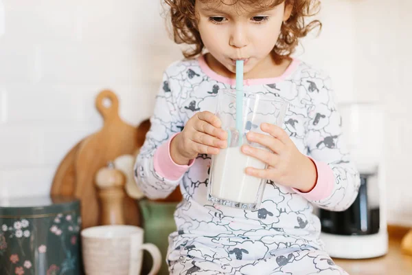 Девочка в пижаме пьет молоко — стоковое фото