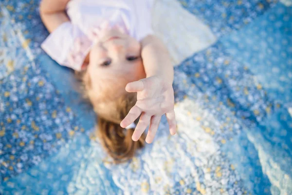 Menina criança deitada no tapete na grama — Fotografia de Stock