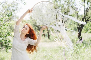 Genç Kızıl saçlı kadın holding beyaz rüya yakalayıcı