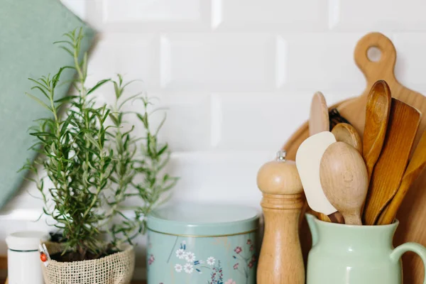 Acessórios de cozinha, detalhes da cozinha, plantas na mesa de madeira, fundo da parede de tijolo cerâmica branca — Fotografia de Stock