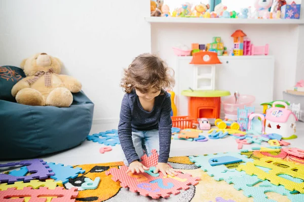 Little girl child playing with numbers puzzle — Stock Photo, Image