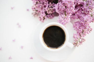 Beyaz dokulu arka planda kahve ve leylak dalı fincan