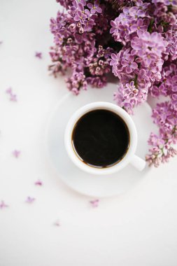 Beyaz dokulu arka planda kahve ve leylak dalı fincan