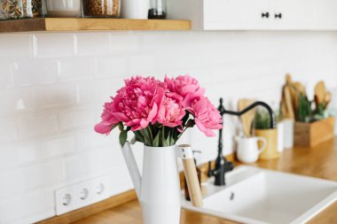 Temiz beyaz mutfağa vazoda şakayık çiçekleri, mutfak ayrıntıları. Sürdürülebilir çevre dostu mutfak