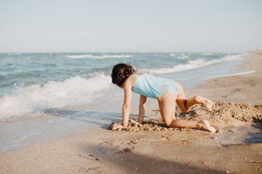 Mutlu kız çocuğu gündüz kumsalda oynuyor. Yaşam tarzı fotoğrafçılığı