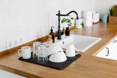 Yıkandıktan sonra mutfak masasındaki temiz bardakları ve tabakları kapatın. Bulaşıkçısız bir hayat. sıfır atık çevre dostu ev