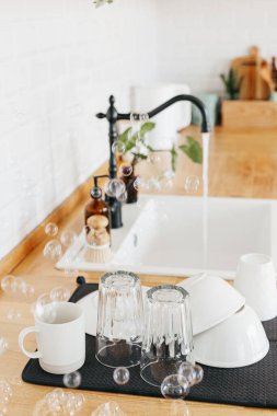 Yıkandıktan sonra mutfak masasındaki temiz bardakları ve tabakları kapatın. Bulaşıkçısız bir hayat. sıfır atık çevre dostu ev