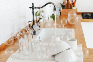 Yıkandıktan sonra mutfak masasındaki temiz bardakları ve tabakları kapatın. Bulaşıkçısız bir hayat. sıfır atık çevre dostu ev