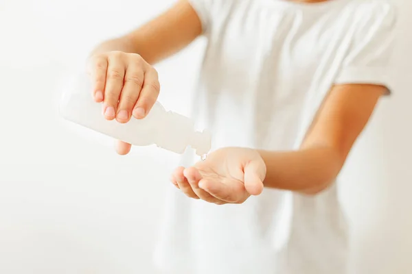 Disinfecting hands. Child taking disinfection alcohol gel on hands in white light to prevent virus epidemic. Prevention of flu disease. Cleaning and disinfecting hands in proper way.