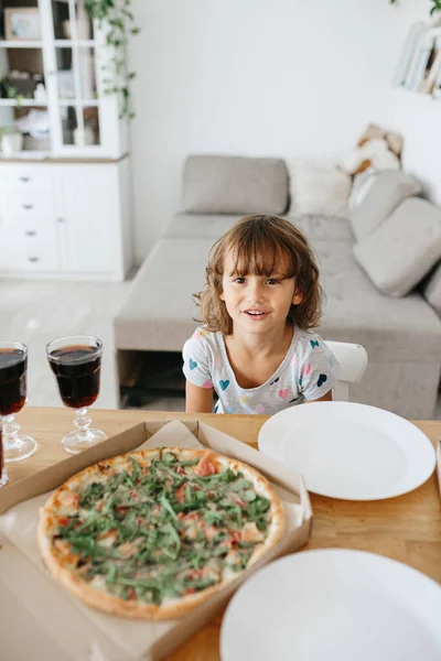 Happy time of eating concept. Kids girl eating pizza at home. Adorable childr enjoy eating pizza with a very happy emotional expressions of face