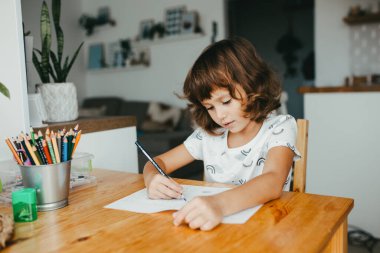 Evde matematik öğrenen beş yaşında tatlı bir kız. Çocuklar için eğitim ve uzak mesafe eğitimi. Evde eğitim kavramı