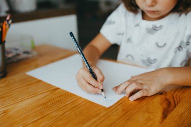 Evinde rakamlar yazan beş yıllık tatlı bir kız. Çocuklar için eğitim ve uzak mesafe eğitimi. Evde eğitim kavramı