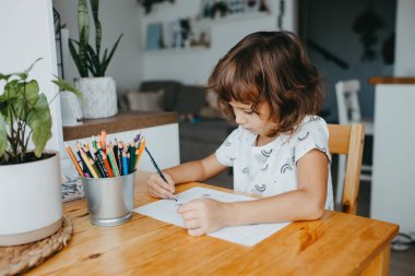 Evde matematik öğrenen beş yaşında tatlı bir kız. Çocuklar için eğitim ve uzak mesafe eğitimi. Evde eğitim kavramı