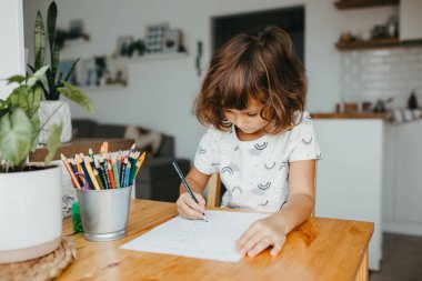 Evde matematik öğrenen beş yaşında tatlı bir kız. Çocuklar için eğitim ve uzak mesafe eğitimi. Evde eğitim kavramı