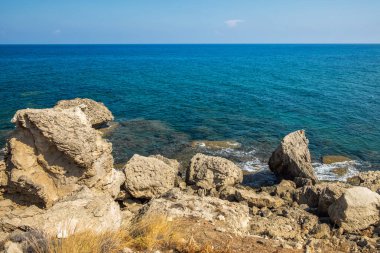 Taş oluşumu ve mavi deniz kıyı şeridi gökyüzü