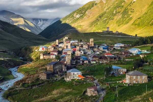 Paisaje de montaña con el famoso pueblo georgiano Ushguli en la luz del atardecer — Foto de Stock