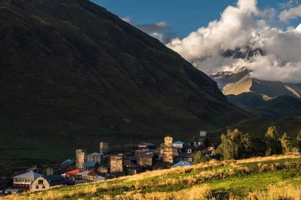 Paisaje de montaña con el famoso pueblo georgiano Ushguli en la luz del atardecer — Foto de Stock