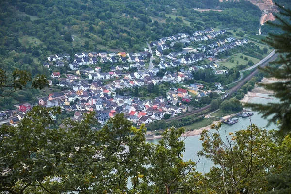 Vista aérea através de folhas de árvore para uma cidade alemã Trechtingshausen no estado de Rheinland-Pfalz com rio Rhein — Fotografia de Stock