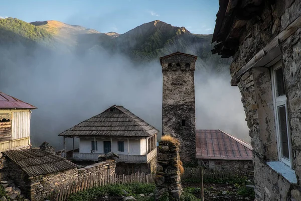Antiguos edificios de alta montaña pueblo de Adishi con montañas y nubes sobre un fondo — Foto de Stock