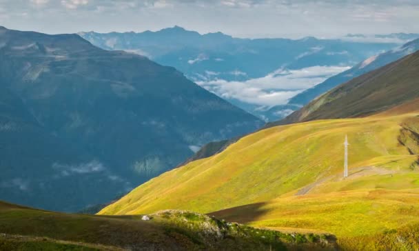 Paisaje timelapse de salida del sol en las montañas vista aérea con polo eléctrico y tienda de campaña turística en un prado verde y nubes — Vídeos de Stock