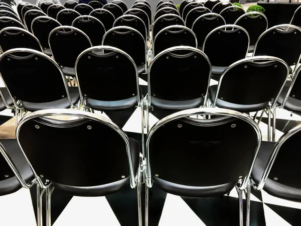 Back View of Black Chairs in Row at the Event