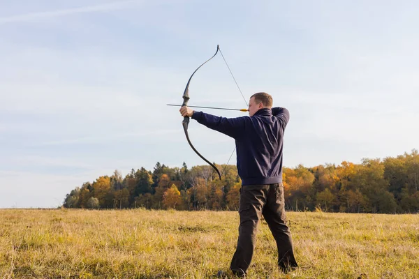 Athlete aiming at a target and shoots an arrow, toned