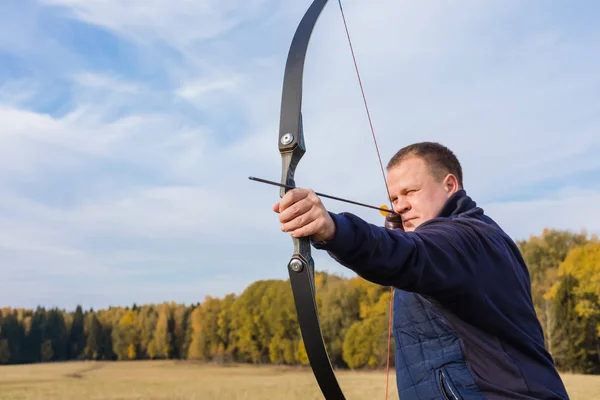 Athlete aiming at a target and shoots an arrow, toned