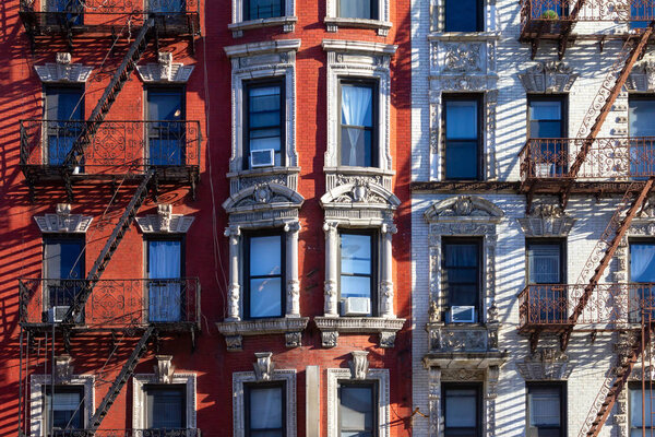 New York City style architecture background with windows and fire escapes on an old apartment building in the East Village of Manhattan