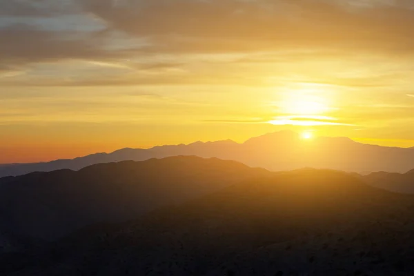 Sunlight shining over a colorful desert mountain landscape in California