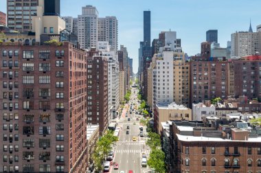 Birinci Bulvar 'ın tepesinde arabalar ve kalabalık caddeyi dolduran insanlar var. Manhattan New York' ta.