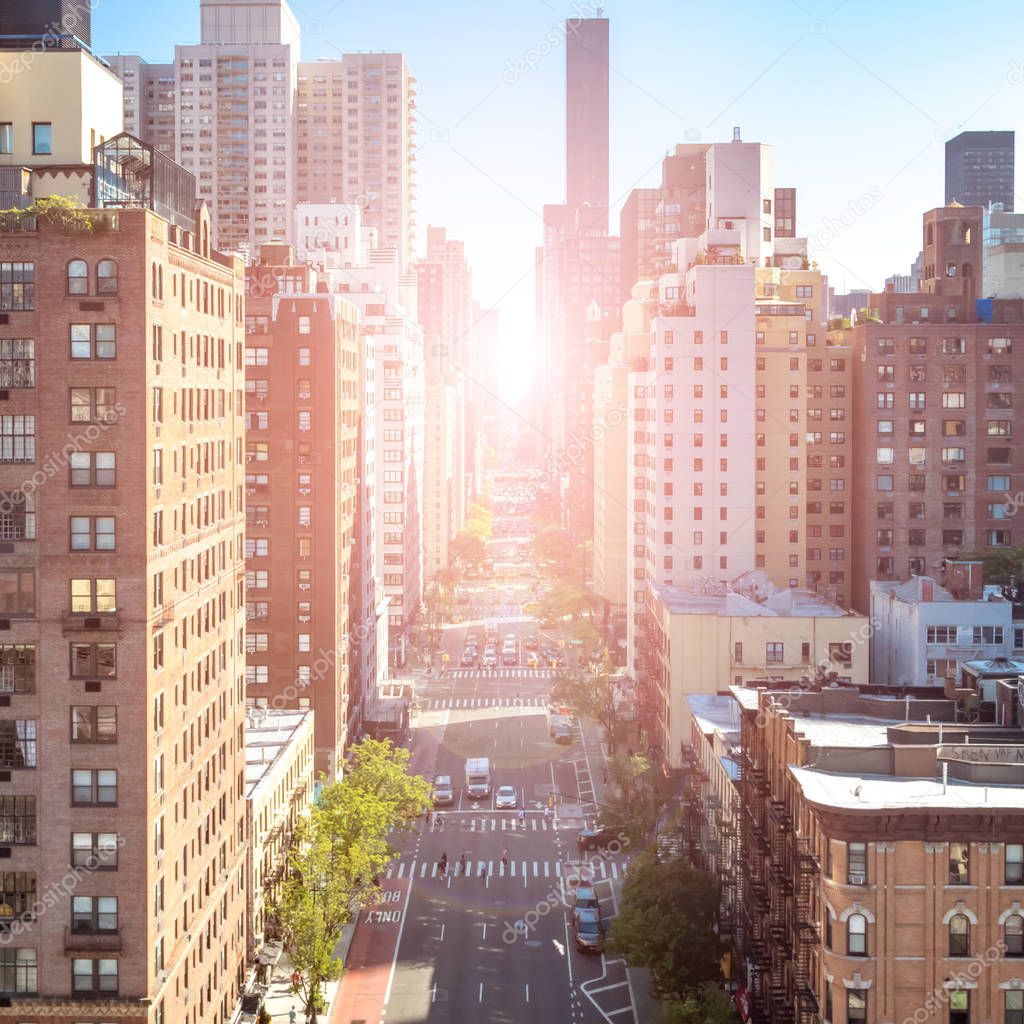 Overhead view of busy street in Midtown Manhattan New York City with sunlight background