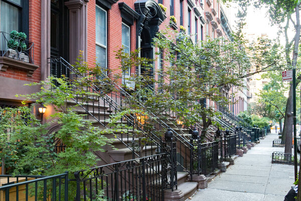 Empty sidewalk in front of historic brownstone buildings in Manhattan New York City NYC