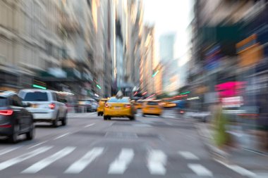 New York sokaklarında hareket halindeki taksilerle bulanık bir sahne.