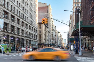 New York City - Temmuz, 2018: Manhattan New York'ta 5th Avenue üzerinde yoğun bir kavşak geçen insanların geçmiş sarı bir taksi hızlı.